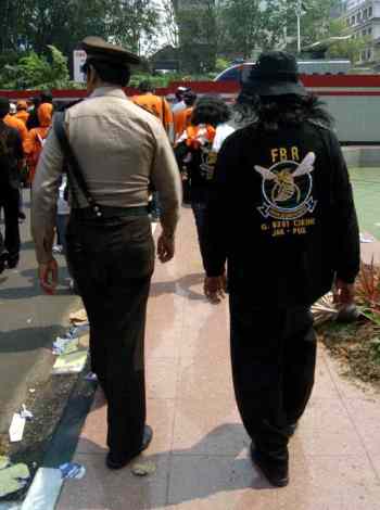 A Jakarta police officer with a member of an ethnic gang. Local gangs often cooperate with, or even supplant, the police in daily policing tasks / Ian Wilson